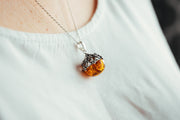 Round, filigree, pendant with Baltic amber.