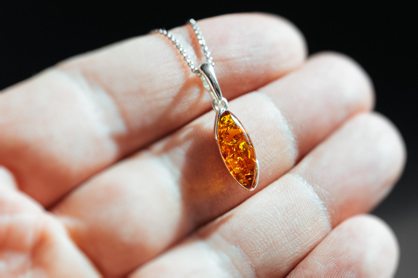 Minimalistic silver pendant with natural amber.