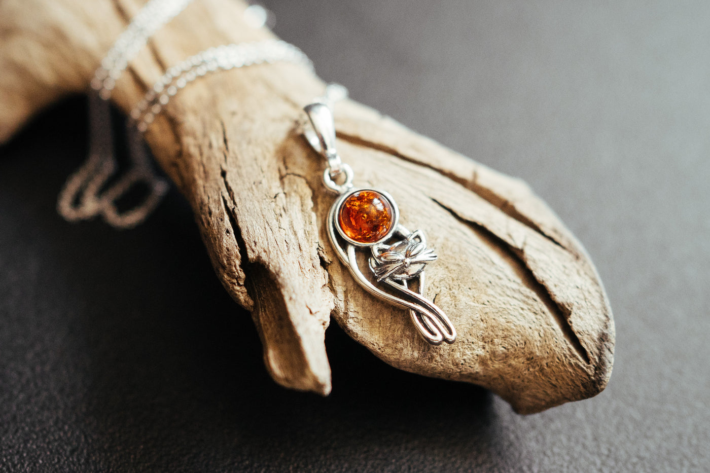 Silver cat charm with natural amber.