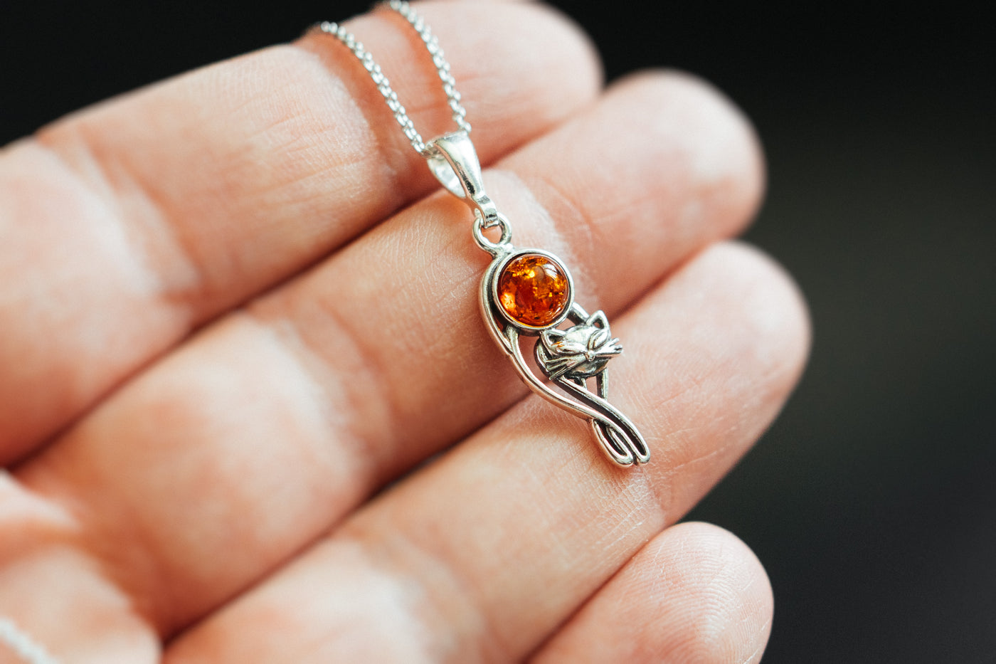 Silver cat charm with natural amber.