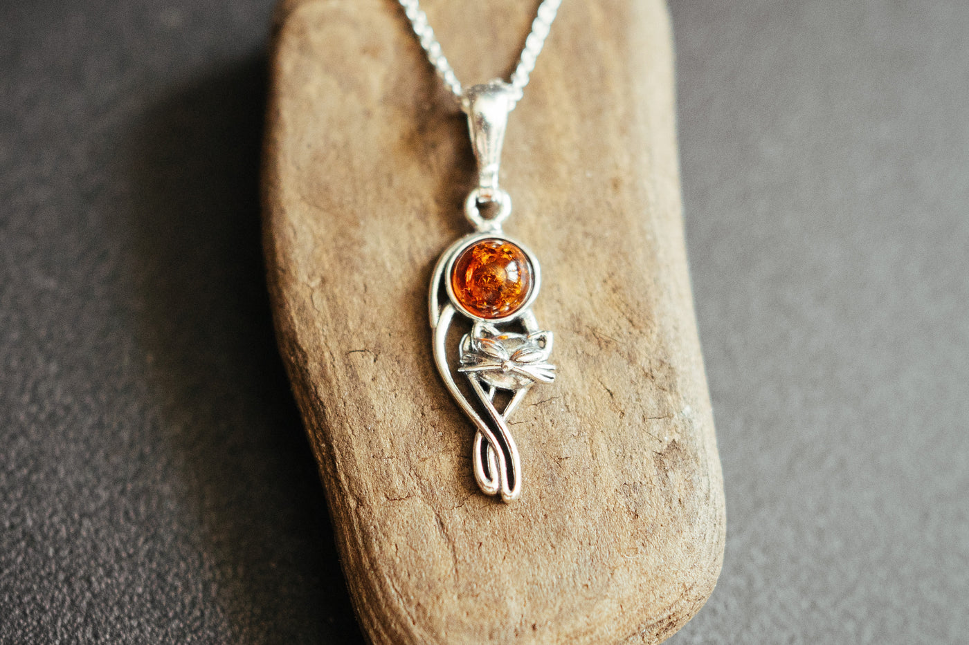Silver cat charm with natural amber.