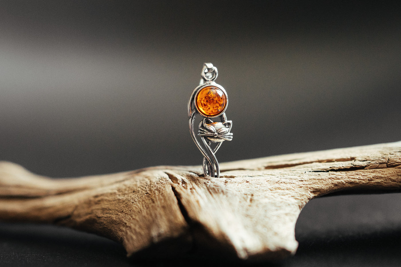 Silver cat charm with natural amber.