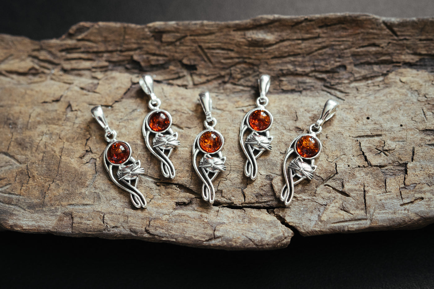 Silver cat charm with natural amber.