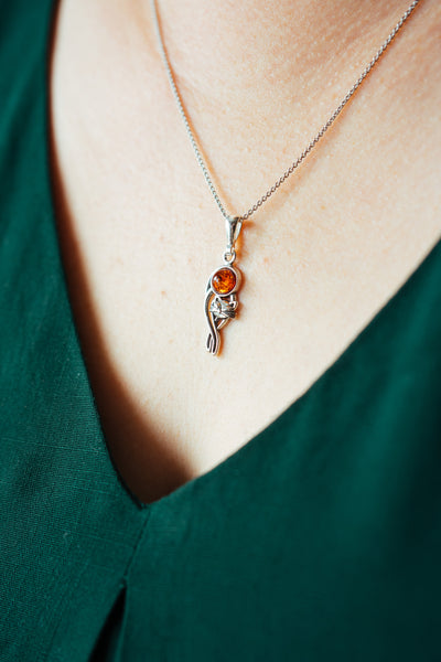Silver cat charm with natural amber.